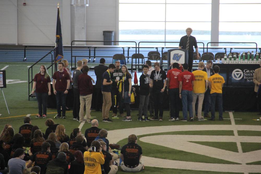 MSO competitors being awarded prize ribbons. Teams receive yellow, white, blue, and red ribbons